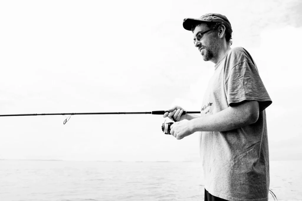 Guest reeling in on a boat fishing trip in Singapore