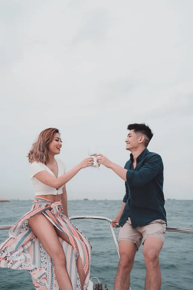 Couple toasting on the bow of a private yacht