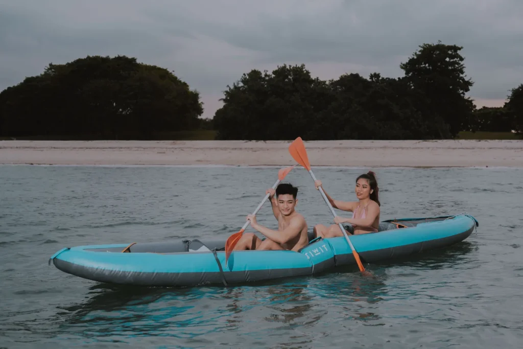 Couple kayaking near the beach in the evening