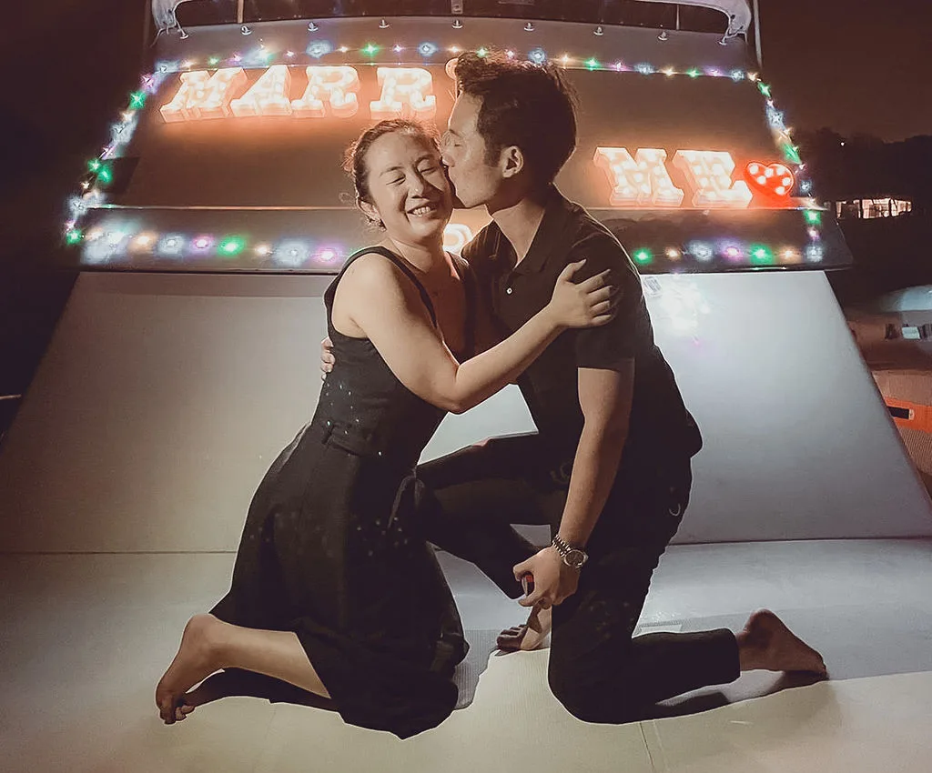 Couple embracing after a yacht proposal in Singapore